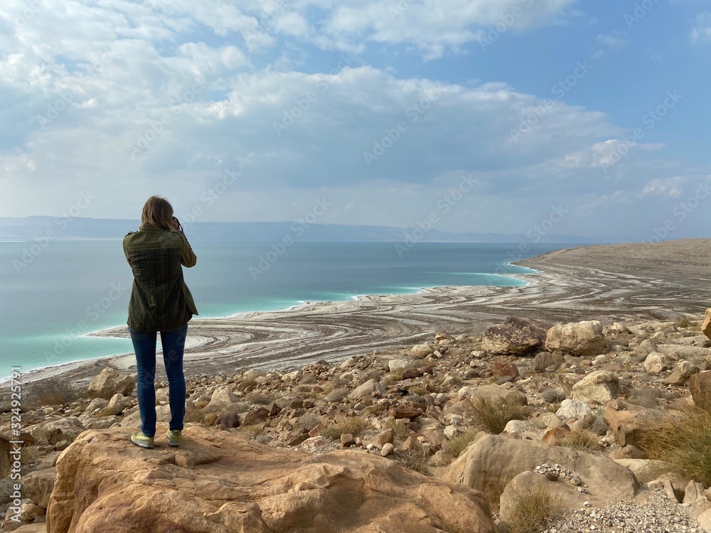 Woman photographing the Death Sea beach in Jordan landscape envi