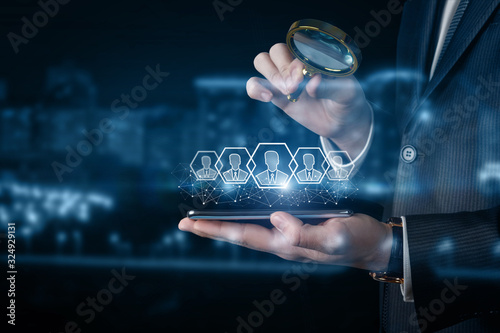 A businessman examines customers on his phone .