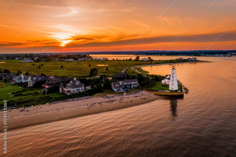 Sunset with homes and lighthouse in the foreground