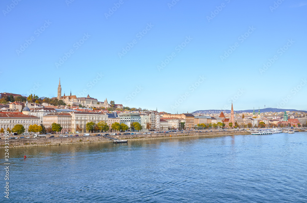 Beautiful cityscape of Budapest, Hungary. Matthias Church, Fishermans Bastion and the historical center in the far background. Waters of the Danube river in the foreground. Horizontal photo