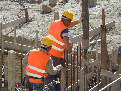 Operaio getta colata di cemento per nuova costruzione in cantiere edile photo