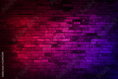 Neon light on brick walls that are not plastered background and texture. Lighting effect red and blue neon background of empty brick basement wall. © lllonajalll