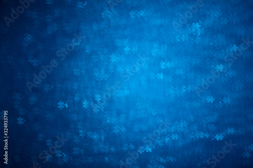 Blue Puzzle shape bokeh. Defocused background for autism awareness day. Real photo. Light blue