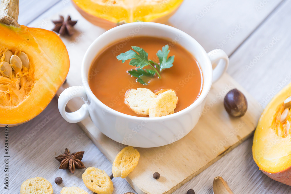 umpkin puree soup, pumpkin, spices on a wooden white background. umpkin puree soup, pumpkin, spices on a wooden white background.