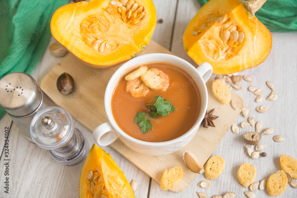 umpkin puree soup, pumpkin, spices on a wooden white background. umpkin puree soup, pumpkin, spices on a wooden white background.