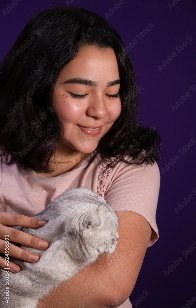 Young latin lady holding a gorgeous white scottish fold cat