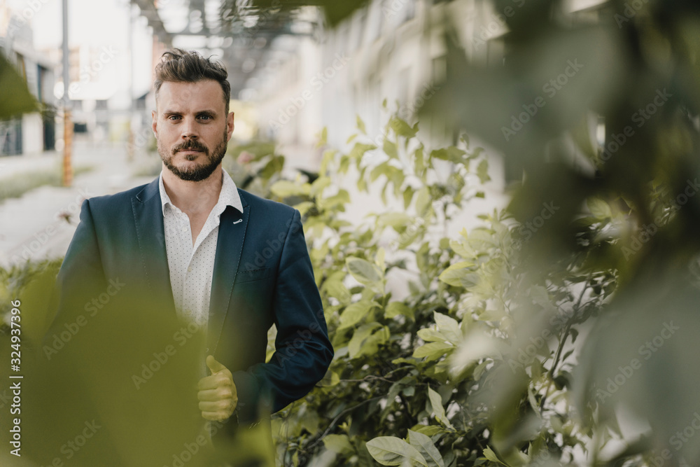 Portrait of smart businessman between plants Portrait of smart businessman between plants