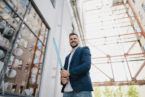 Wallpaper Mural Smiling businessman holding toy sword Torontodigital.ca