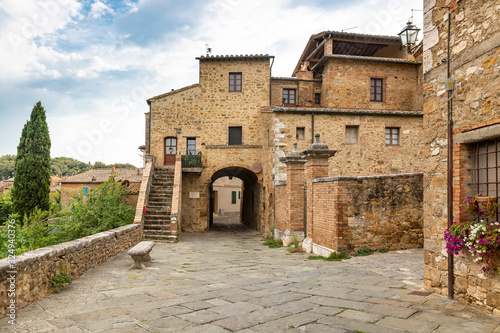 a street with typical houses in San Quirico d'Orcia, Province of Siena, Tuscany, Italy photo