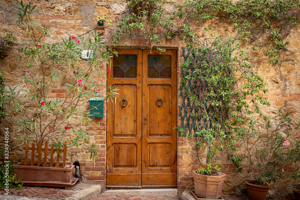 a closed door of an antique cozy house decorated with flowers