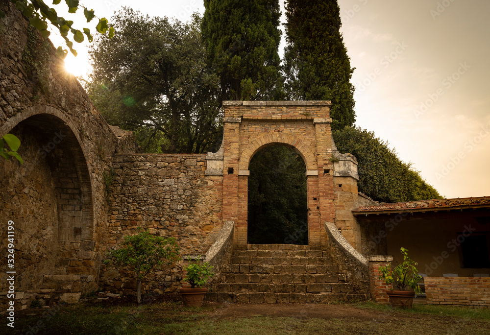 antique gate and wall in the Giardino delle Rose garden in San Quirico d'Orcia, Province of Siena, Tuscany, Italy