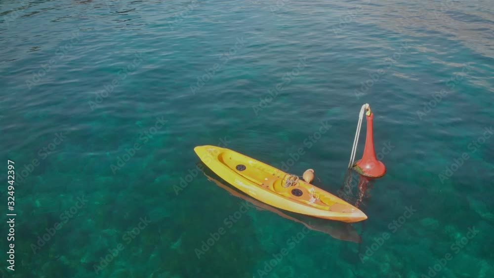 Aerial: A Kayak tied to a buoy in clear tropical waters Aerial: A Kayak tied to a buoy in clear tropical waters