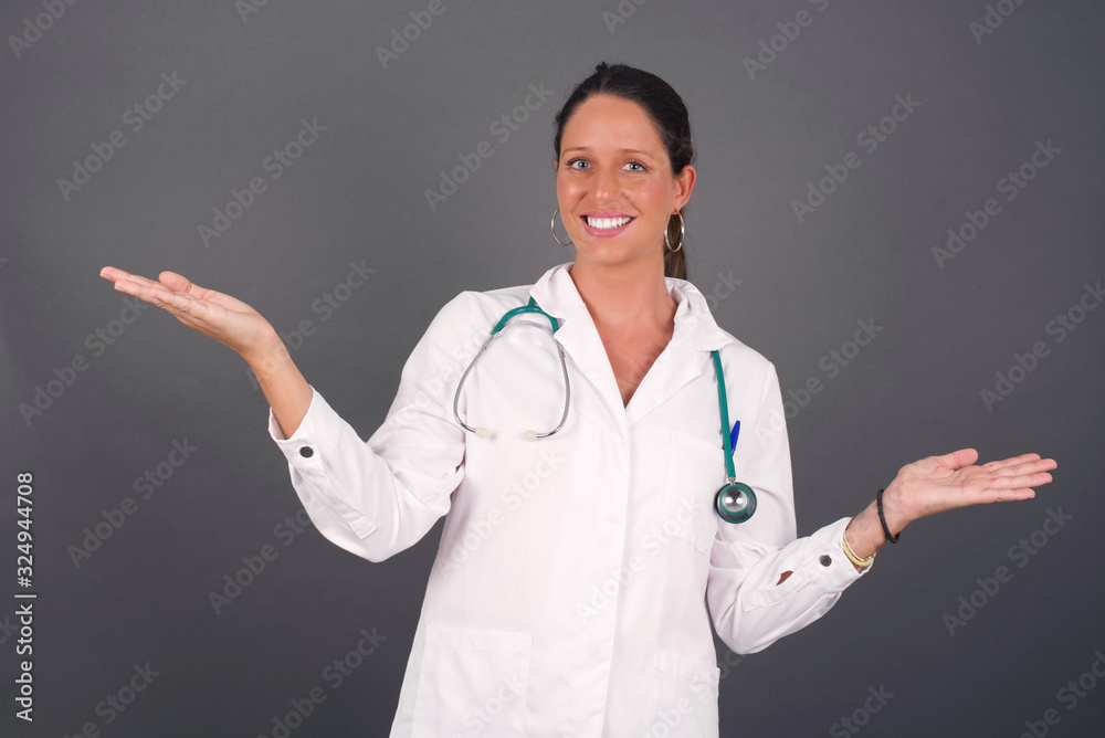 Cheerful doctor woman wearing making a welcome gesture raising arms over head isolated on white background. Cheerful doctor woman wearing making a welcome gesture raising arms over head isolated on white background.