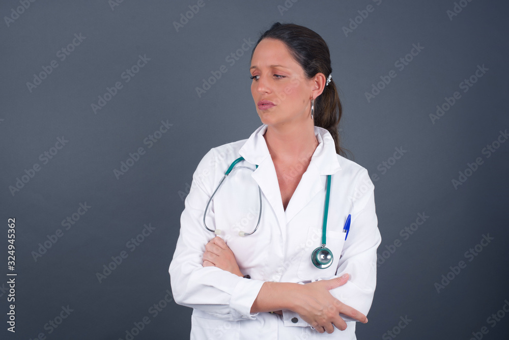 Closeup portrait displeased pissed off angry grumpy pessimistic doctor woman with bad attitude, arms crossed looking sideways. Negative human emotion facial expression feelings