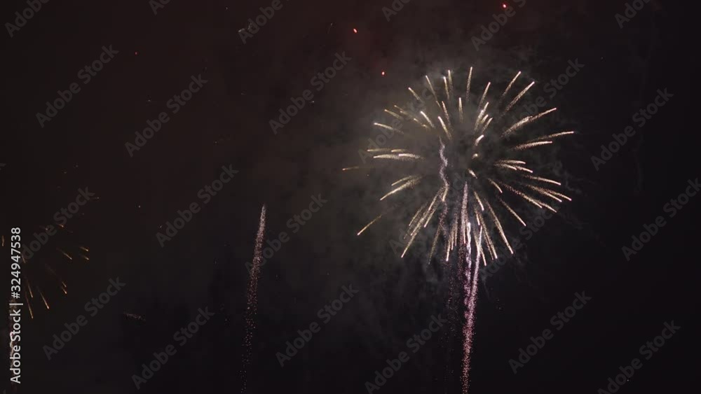 Real fireworks with multicolored rocket explosions in the night sky at new year's eve.