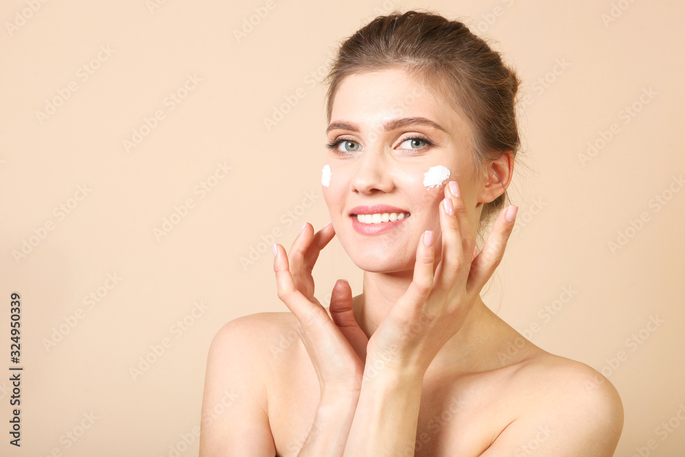 Φωτογραφία Portrait of a beautiful young girl on a colored background who uses caring cream