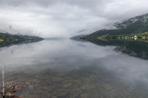 Beautiful view of the Norwegian fjords with turquoise water surrounded by cloudy sky, selective focus