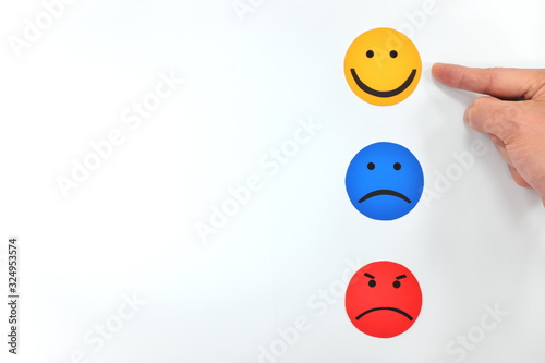 Happy, sad and angry face icon in white background. Hand choosing happiness. Customer satisfaction and service feedback concept.