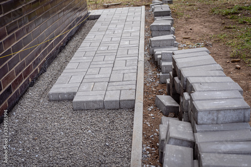 Photography Laying gray concrete paving slabs in a house walkway