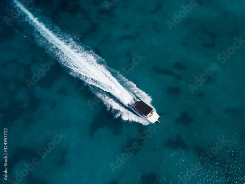 Motor speedboat moving on crystal emerald sea water. Above drone view © ilyaska