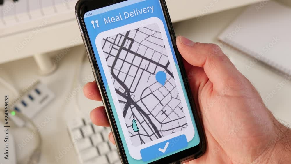 Meal delivery app on a smartphone showing on a live map the delivery car approaching its destination.