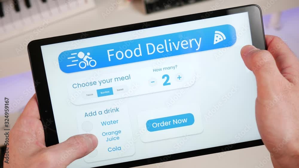 Ordering a meal from a restaurant online with a food delivery app on a tablet screen. Choosing from the menu and paying online.