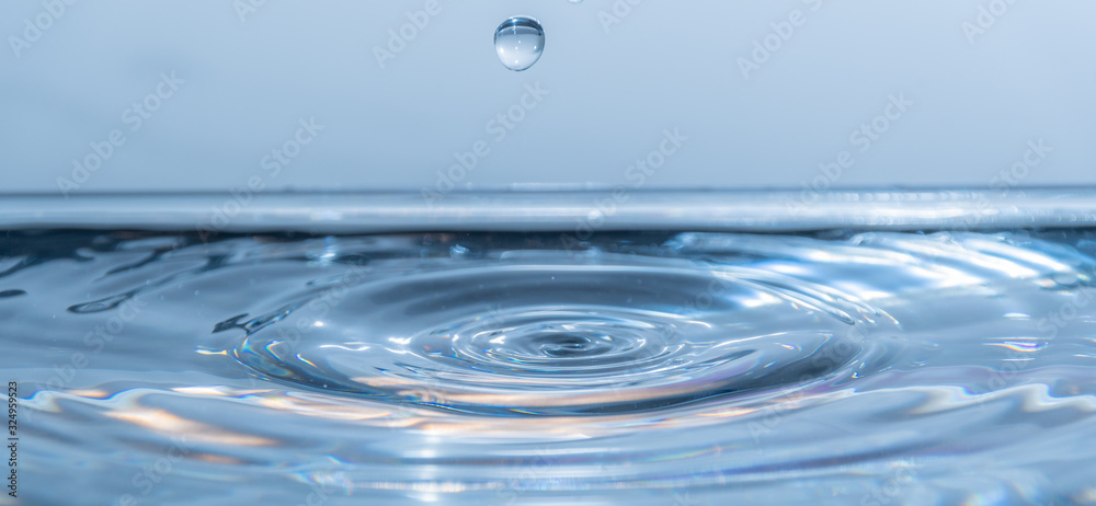 Fallende Wassertropfen in das Wasser mit wellen Fallende Wassertropfen in das Wasser mit wellen
