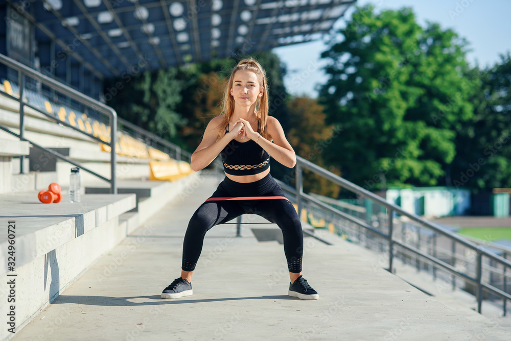 Young sporty woman doing exercises with rubber band outdoor Young sporty woman doing exercises with rubber band outdoor