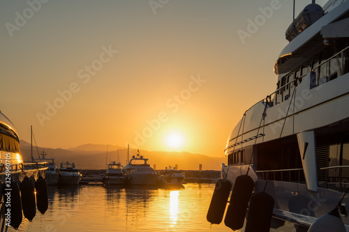 Beautiful sunrise in a famous port in the south of spain, with luxury yachts and see different parts of the boats © Emilio