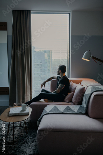 man sitting on sofa at home