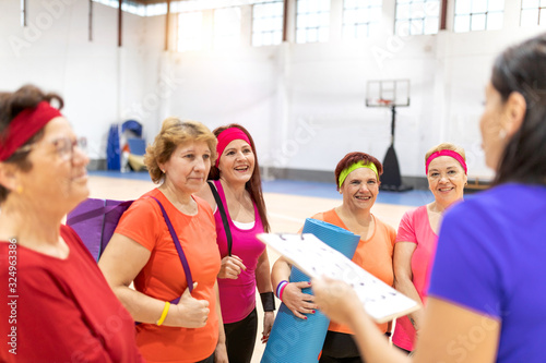 older women doing gymnastics and yoga in the ward with coach