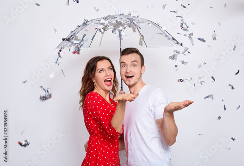 Young couple in love embracing under confetti in decorated studio. photo