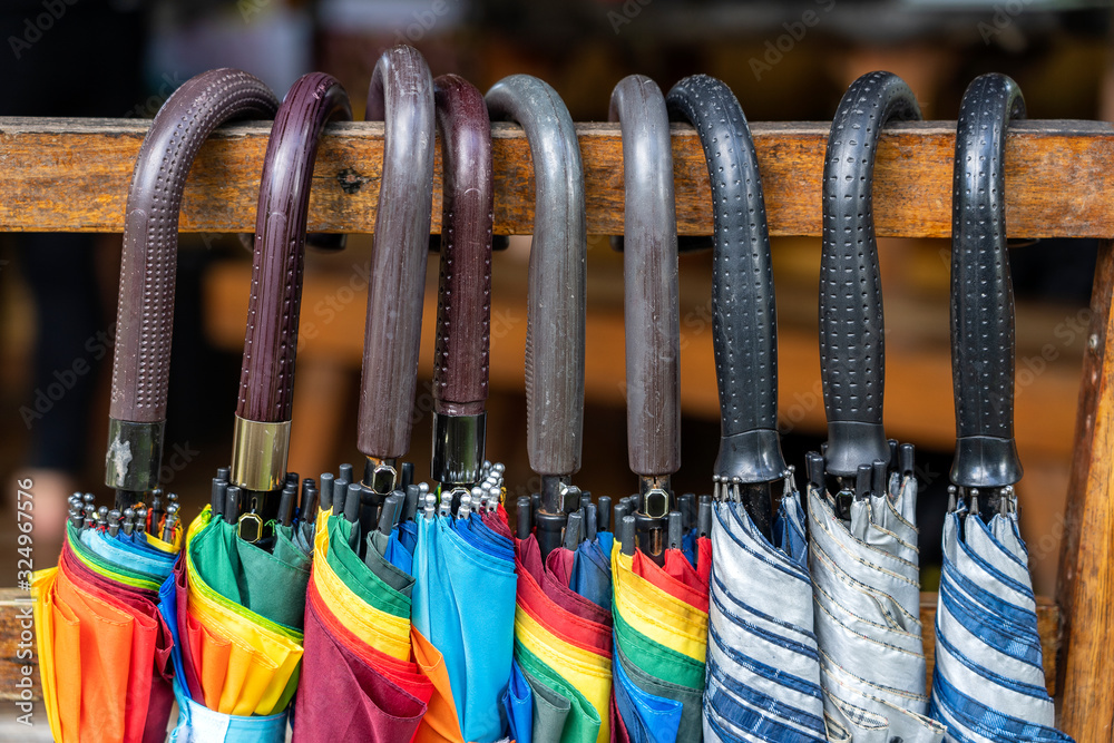 Many umbrellas with plastic handles, close up