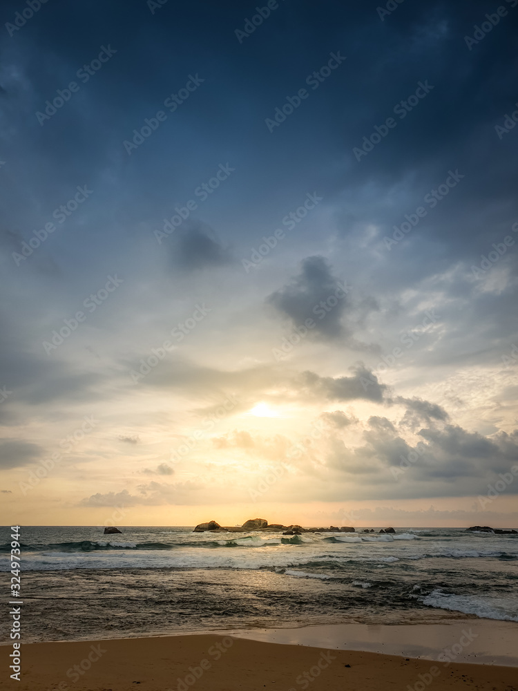 Beautiful landscape of sun shining through dark clouds on the ocean