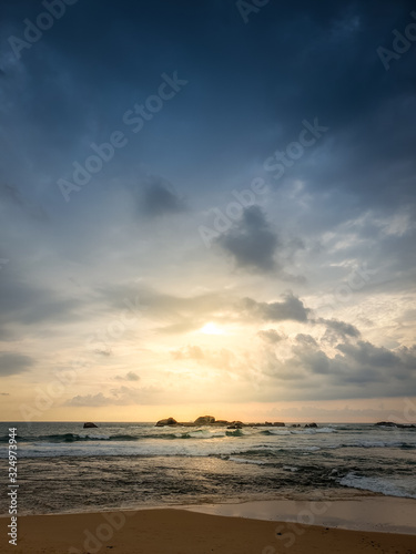 Beautiful landscape of sun shining through dark clouds on the ocean