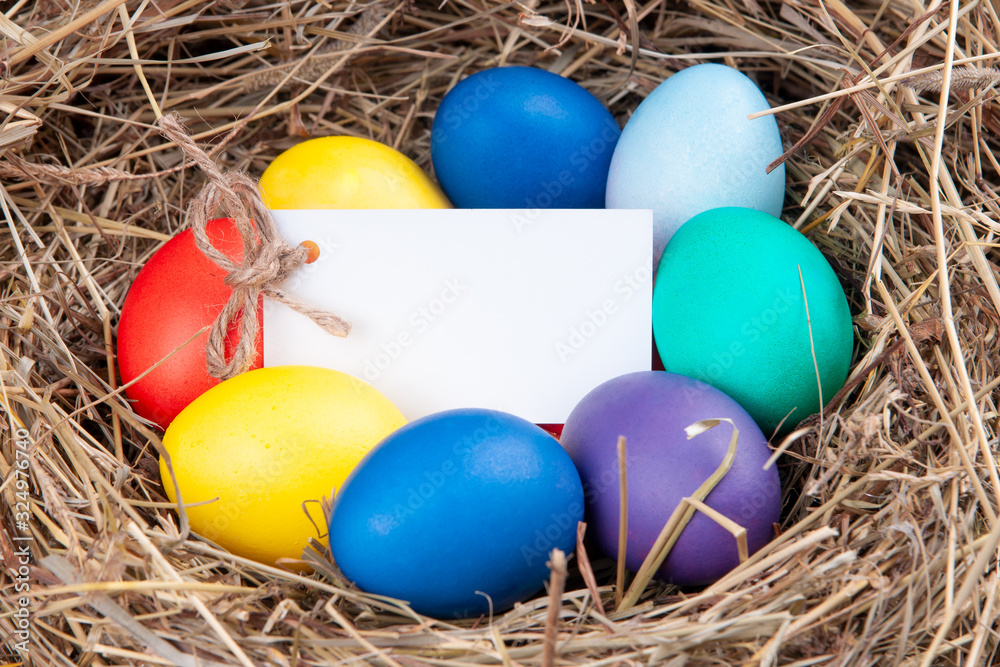 Multicolored eggs with a note in the hay. Mock up, concept easter. Multicolored eggs with a note in the hay. Mock up, concept easter.