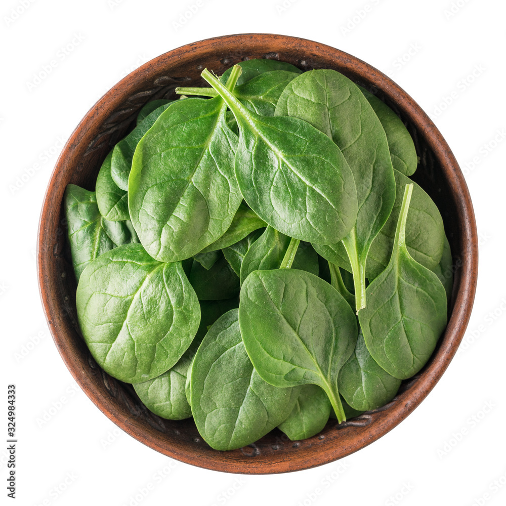 Fresh spinach leaves in a clay bowl isolated on a white background. Food for fitness. The view from the top.
