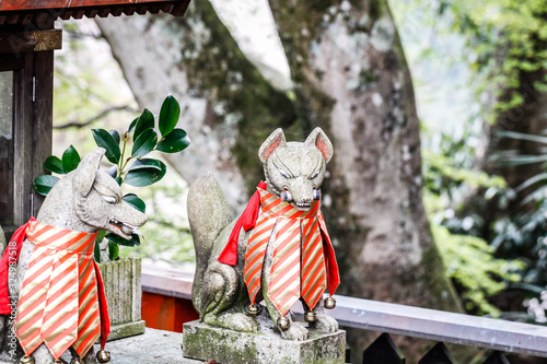 Japanese fox stone statue in front of a little temple in Yoshinoyama photo