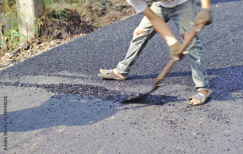 Obraz premium Road construction worker Stone mixing asphalt Asphalt road construction, shovels, road maintenance, Asians, Rural construction, Developing countries, Rural development, Developing countries, 