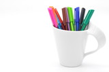 colorful pens in a white cup isolated on white background