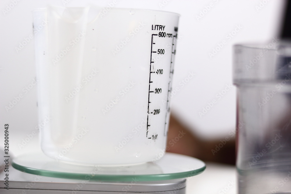 Measuring Cup on Kitchen Scale. Making Lemon Mascarpone Pie Series. Measuring Cup on Kitchen Scale. Making Lemon Mascarpone Pie Series.