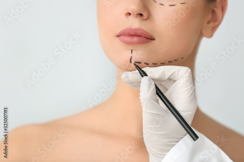 Plastic surgeon applying ma...
