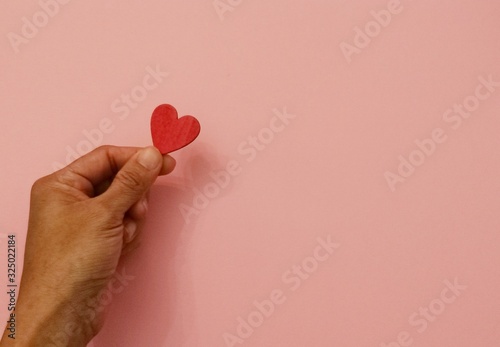 Valentines day concept, Love concept, Woman hand holding red heart with white wooden background and copy space.