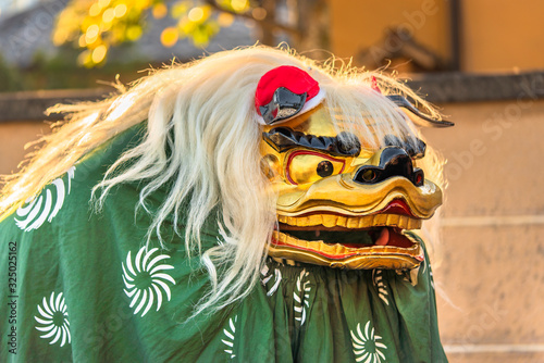 Japanese dancer who wears the new year's  traditional Shishimai lion costume composed of a wooden head with eyes gilded in gold and teeth plated with gold as well as to the ears that moved photo