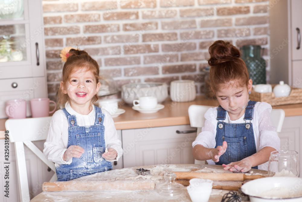 Funny kid girls 3 and 5 year old making ginger bread in kitchen closeup. Looking at camera. Childhood. Preparation. Funny kid girls 3 and 5 year old making ginger bread in kitchen closeup. Looking at camera. Childhood. Preparation.