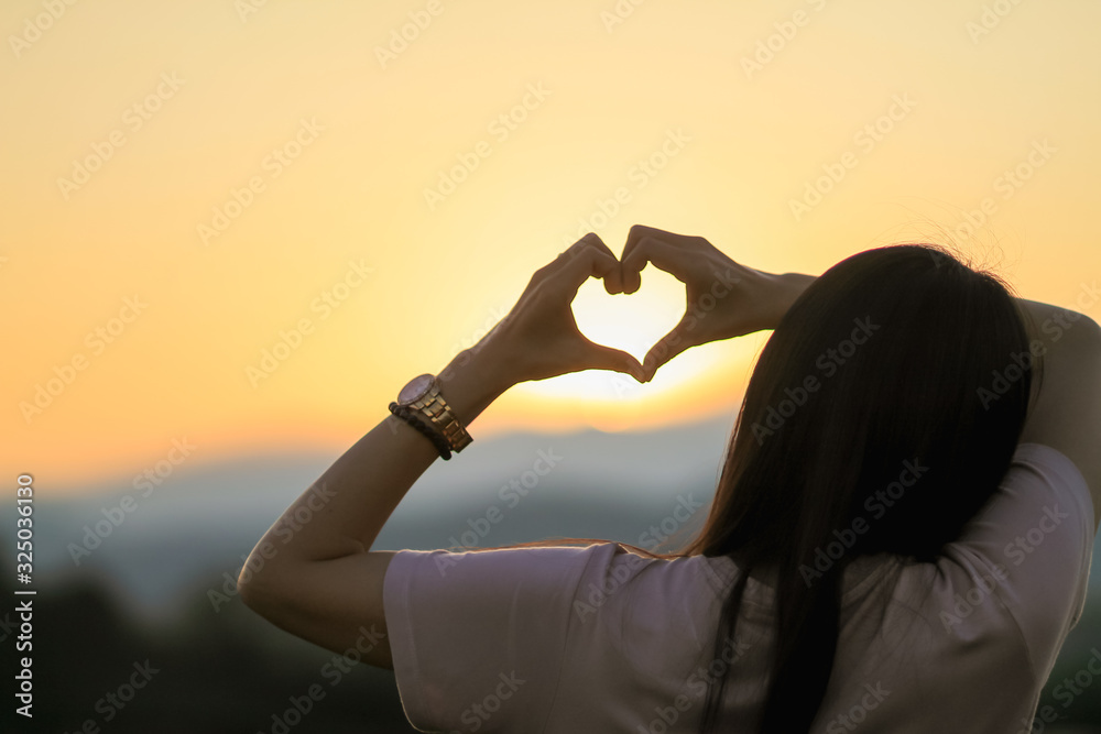 Ταπετσαρία An Asian woman shows a heart symbol to tell her lover on Valentine's Day and the symbol showing love and friendship that has always been