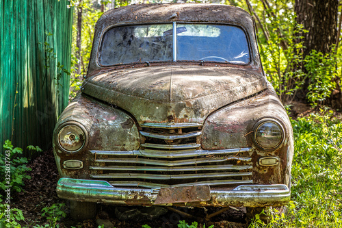 An old rusty abandoned car outdoors. broken car close-up view