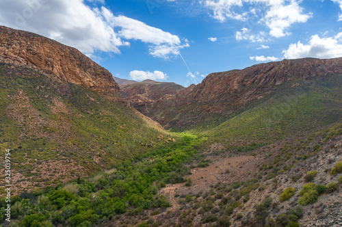 African mountain landscape with green mountain valley and dry arid mountains © Olga K