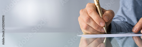 Close-up Of Hand Filling Cheque photo
