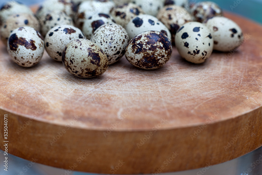 Fototapeta premium Quail eggs on a wooden board with side view